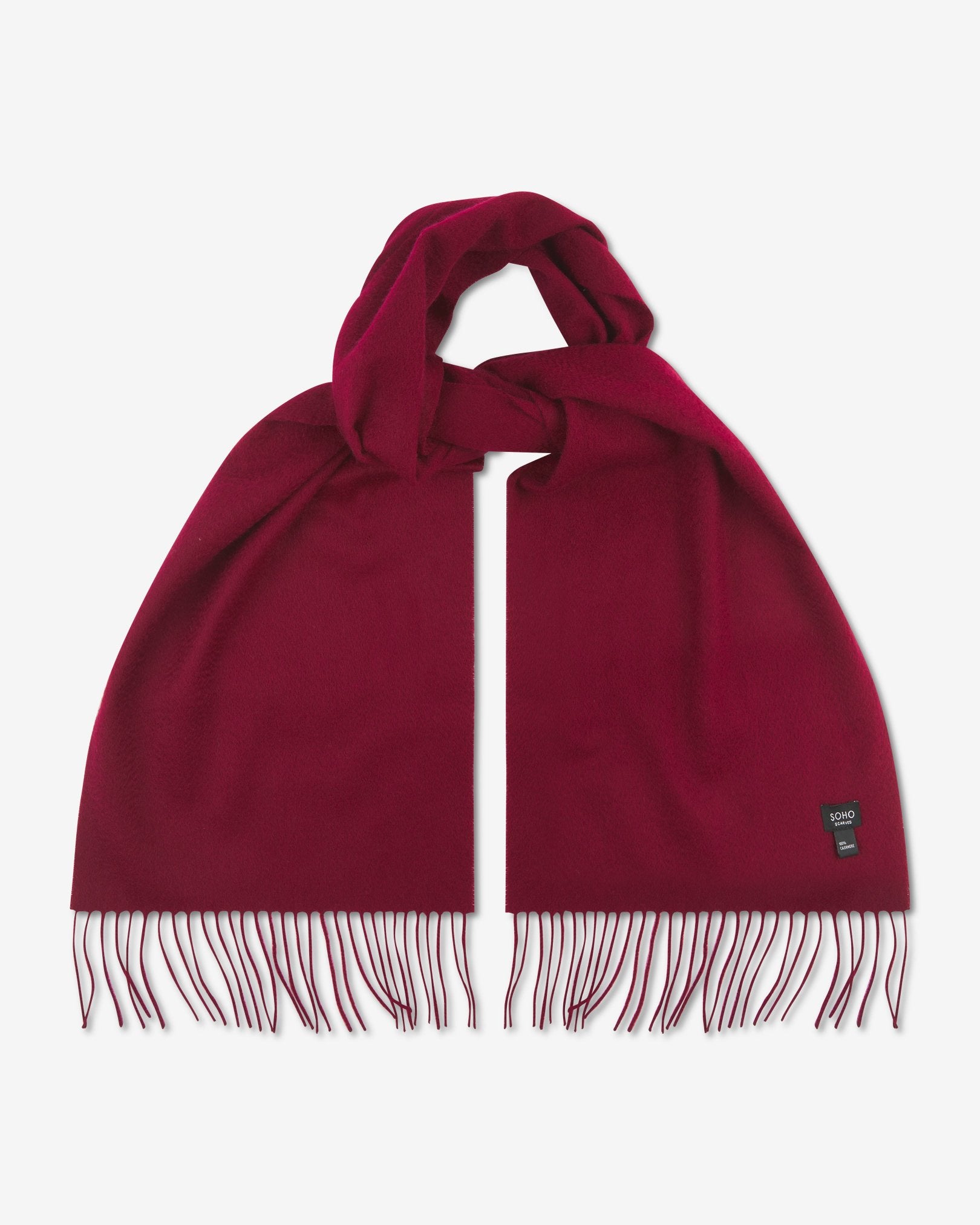 Looped wine-red cashmere scarf with both ends parallel and fringe extended. View of SOHO Scarves branding label on bottom-right portion of the scarf.