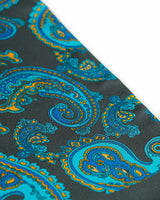 Angled closer view of the dark grey silk scarf with focus on the cyan paisley patterns and additional blue and gold patterns.