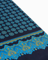 Angled view of the black scarf with yellow-gold, mid-blue and light green detailing, and a focus on the elegant paisley inspired border pattern.