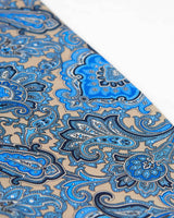 Angled view of fawn patterned scarf, focussing on the various blue paisley and floral-inspired patterns.