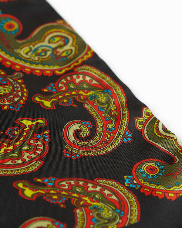 Angled closer view of the black silk scarf with focus on the ornate multi-coloured paisley patterns.