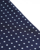 Angled view of the dark blue and white polka dot scarf.