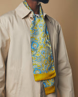 Close up of model wearing 'The Compton' yellow and cyan wool backed scarf with clear view of paisley patterns and lemon-yellow border tips.
