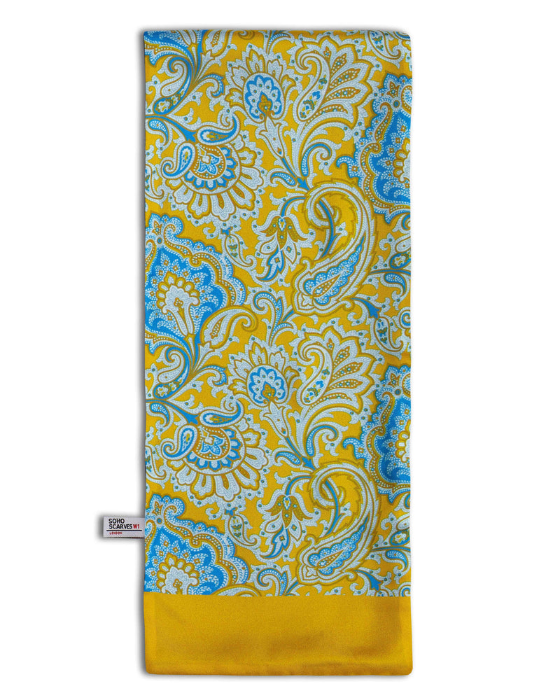 'The Compton Wool' wool backed scarf arranged in a rectangular shape, clearly showing the multi-coloured paisley patterns, golden yellow border and the ‘Soho Scarves’ label on the left edge.