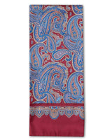 ‘The Hedge’ dress scarf arranged in a rectangular shape with a focus on the intricate multicoloured patterns and ornate border set on a deep red ground.