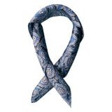 Square scarf rolled into a loop, showing the sheen of the silk neckerchief fabric with blue paisley patterns enhanced with white and grey accents.