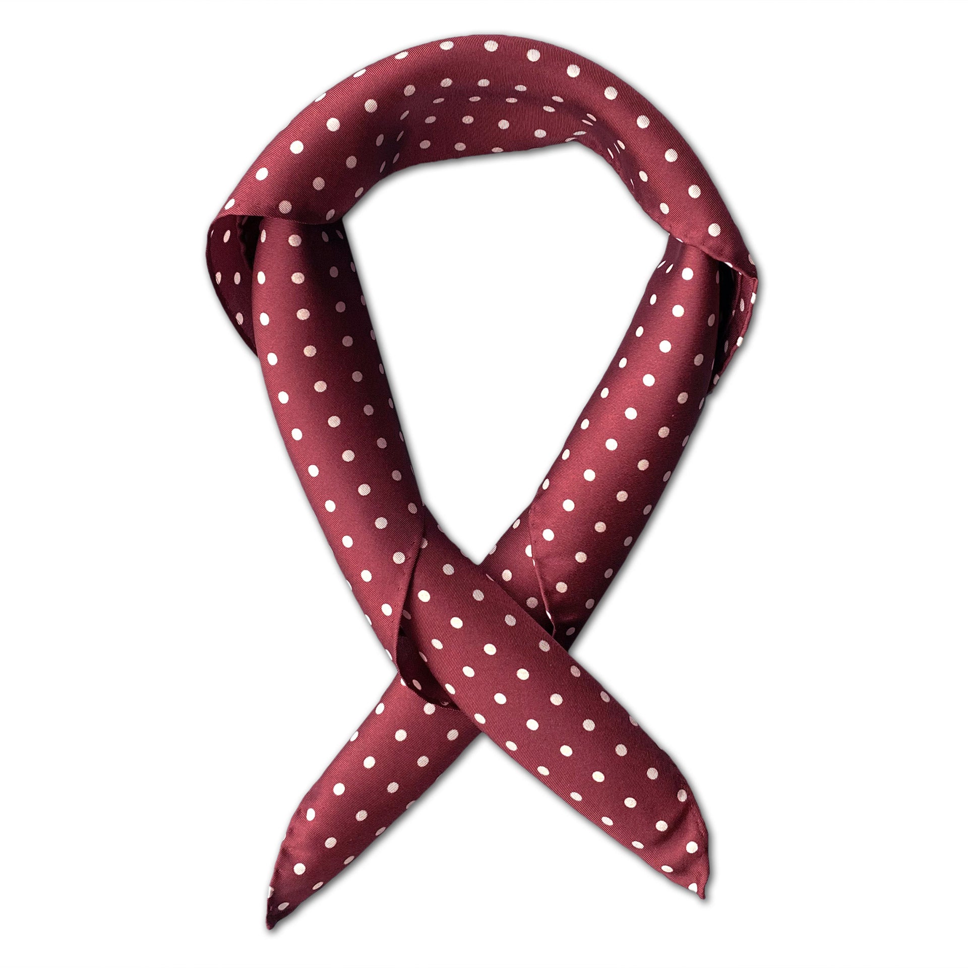 Square scarf rolled into a loop, showing the timeless white polka-dot pattern on a maroon background.